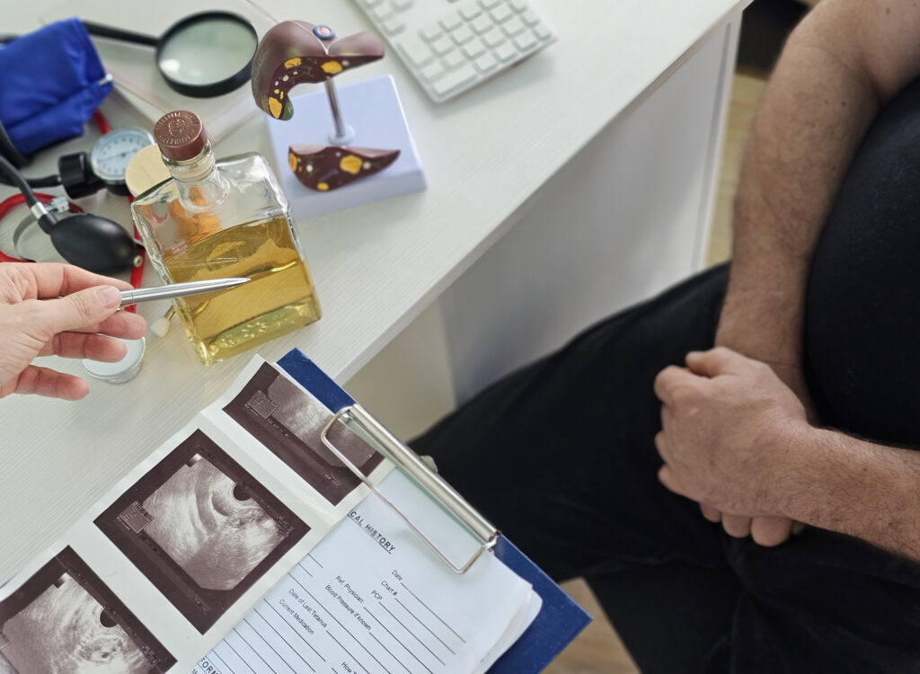 Doctor explaining alcoholic cirrhosis diagnosis with liver model and ultrasound scans to patient in Spokane WA