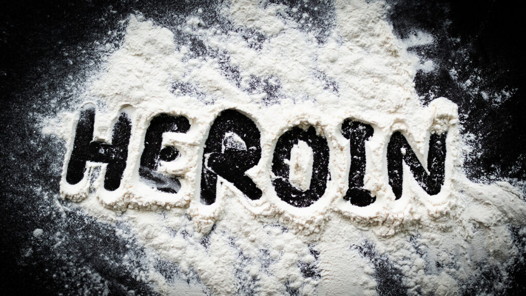 Word “Heroin” written in white powder symbolizing heroin addiction and substance abuse in Spokane WA