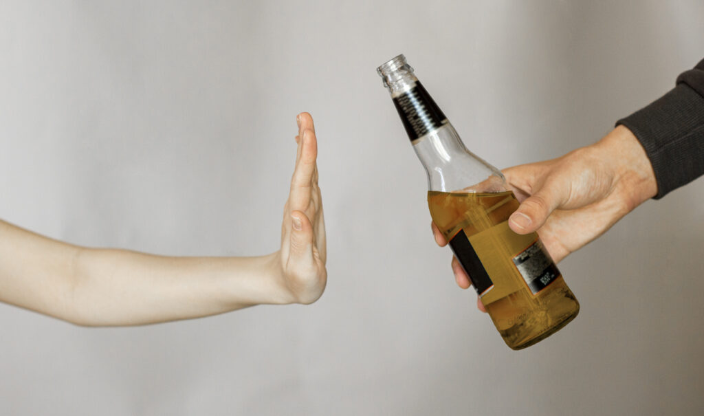 Hand refusing alcohol drink as an example of quitting cold turkey in Spokane WA