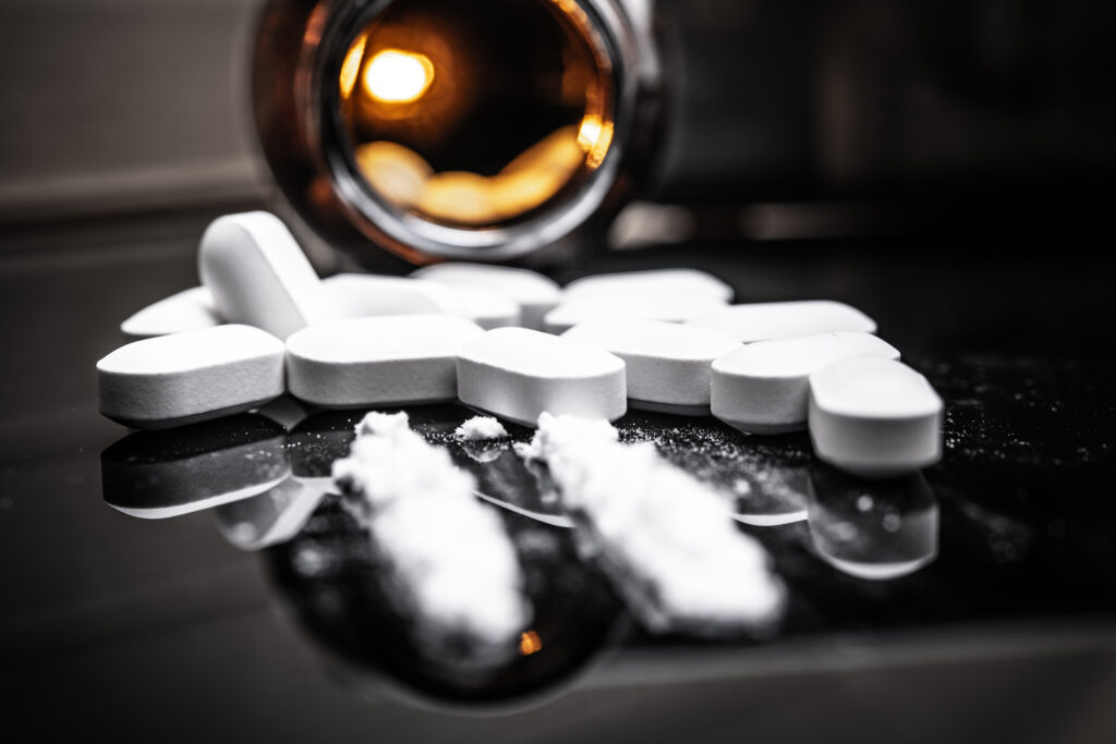 Close-up of white pills and powder spilled from a bottle, symbolizing drug overdose symptoms and risks in Spokane, Spokane Valley, and Washington State.
