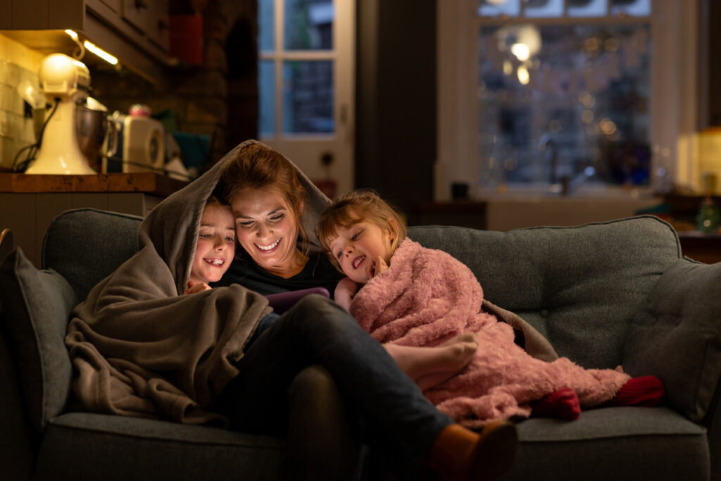 happy mother relaxing on the couch with two children, representing alcohol-free living and what is sobriety for families in Spokane, WA and Spokane Valley