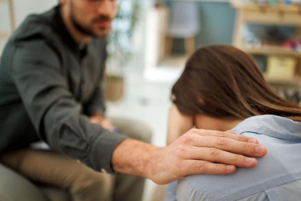 Counselor placing a supportive hand on a person’s shoulder — how to help someone with depression in Spokane, WA