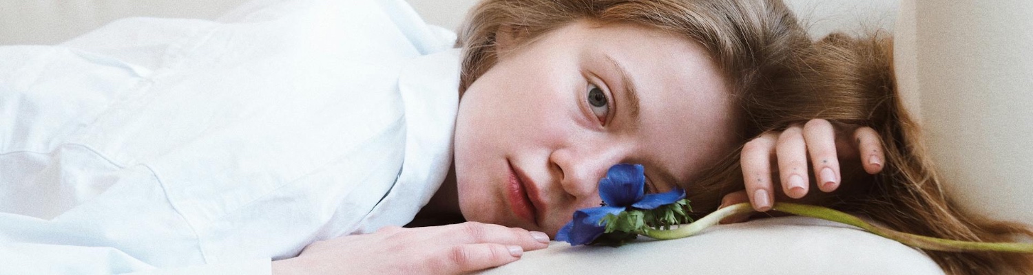 A person addicted to depression, lying on a sofa with a blue flower