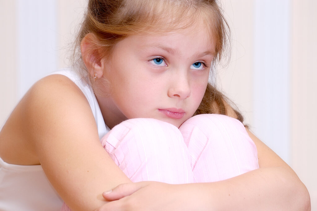 Sad young girl hugging her knees BPD and childhood trauma awareness in Spokane, WA