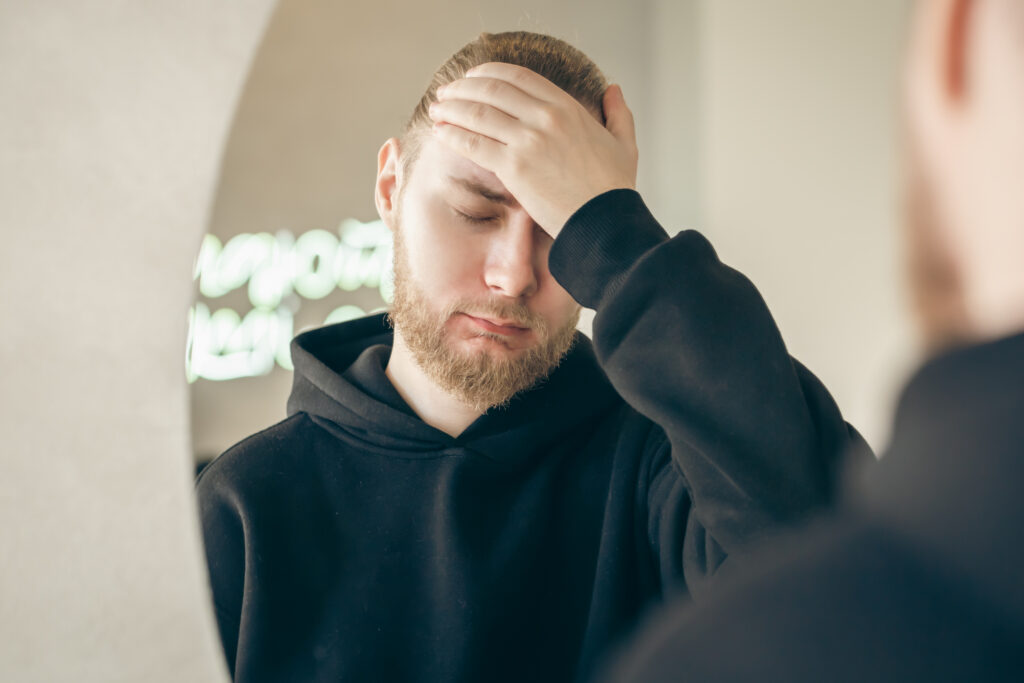 man covering face while reflecting on symptoms and starting dbt for borderline personality disorder, photographed indoors in Spokane, WA with Washington State resources
