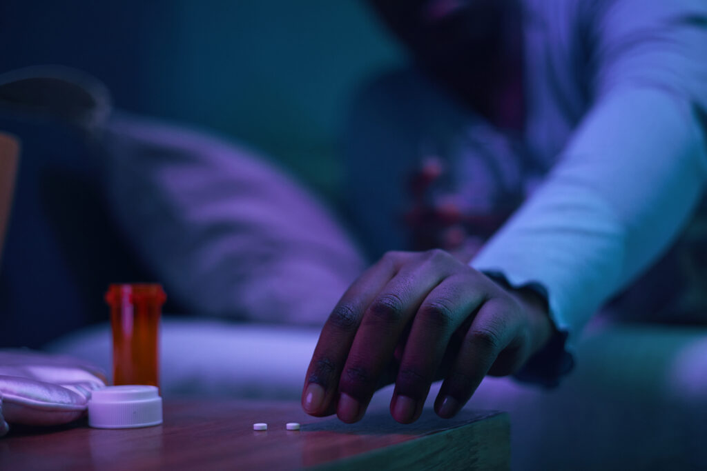 Person reaching for anxiety medication on a bedside table, representing propranolol for anxiety treatment in Spokane WA