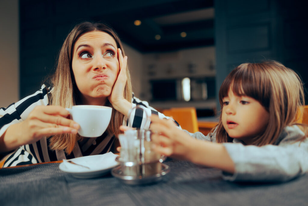 Mother drinking coffee while managing child, illustrating caffeine and ADHD effects in Spokane WA