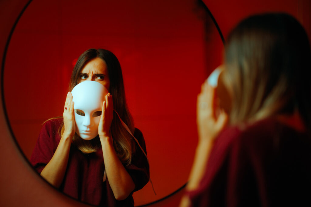 covert narcissist woman hiding behind a mask