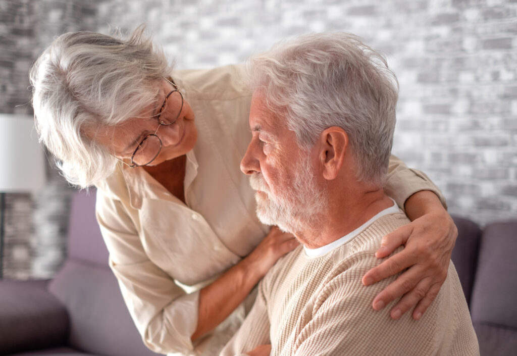 Senior woman comforting her husband who appears sad, representing emotional support and the use of the Geriatric Depression Scale in Spokane Valley, Washington.